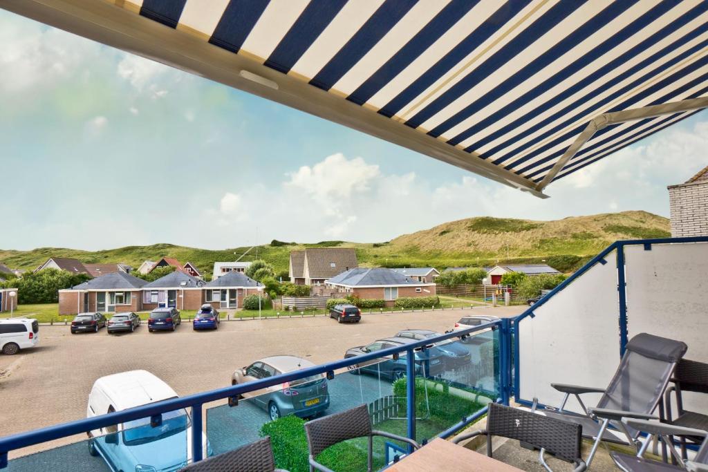 a balcony with a view of a parking lot at Seinpost Appartment in Callantsoog