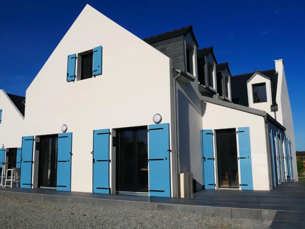 a white house with blue doors and windows at Loc' Maria - Grands Sables in Groix