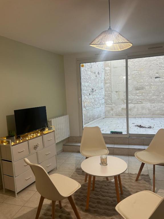 a living room with chairs and a table and a tv at nid douillet in La Roche-Posay