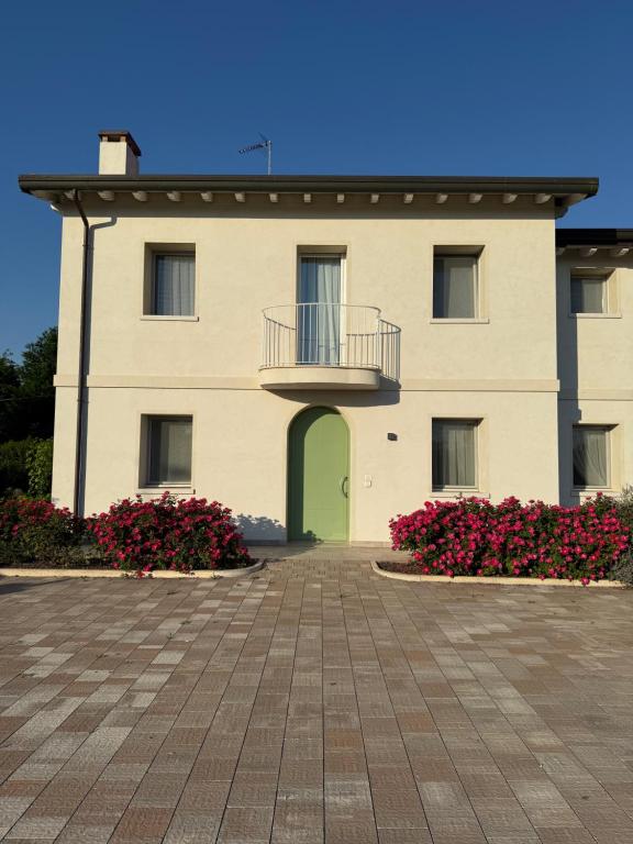 a large building with a green door and flowers at Ca' Maggiolo in Cinto Caomaggiore