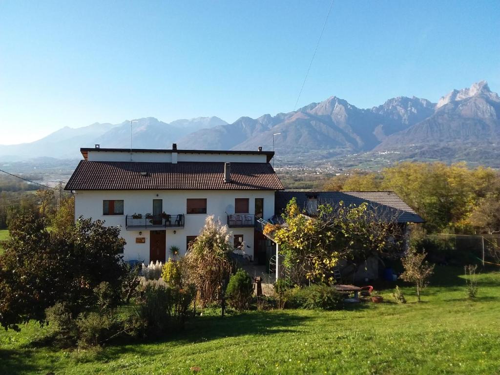 dom w polu z górami w tle w obiekcie B&B Panorama Dolomiti w mieście Mel