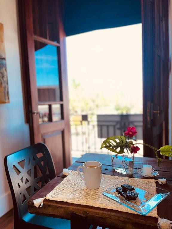 a table with a cup of coffee and a vase on it at Mayo apparts in Esperanza