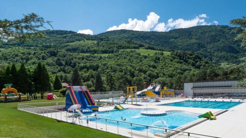 a large swimming pool with a mountain in the background at ZEcamping 3 étoiles animaux acceptés restaurant et Canoë Kayak in Aigueblanche
