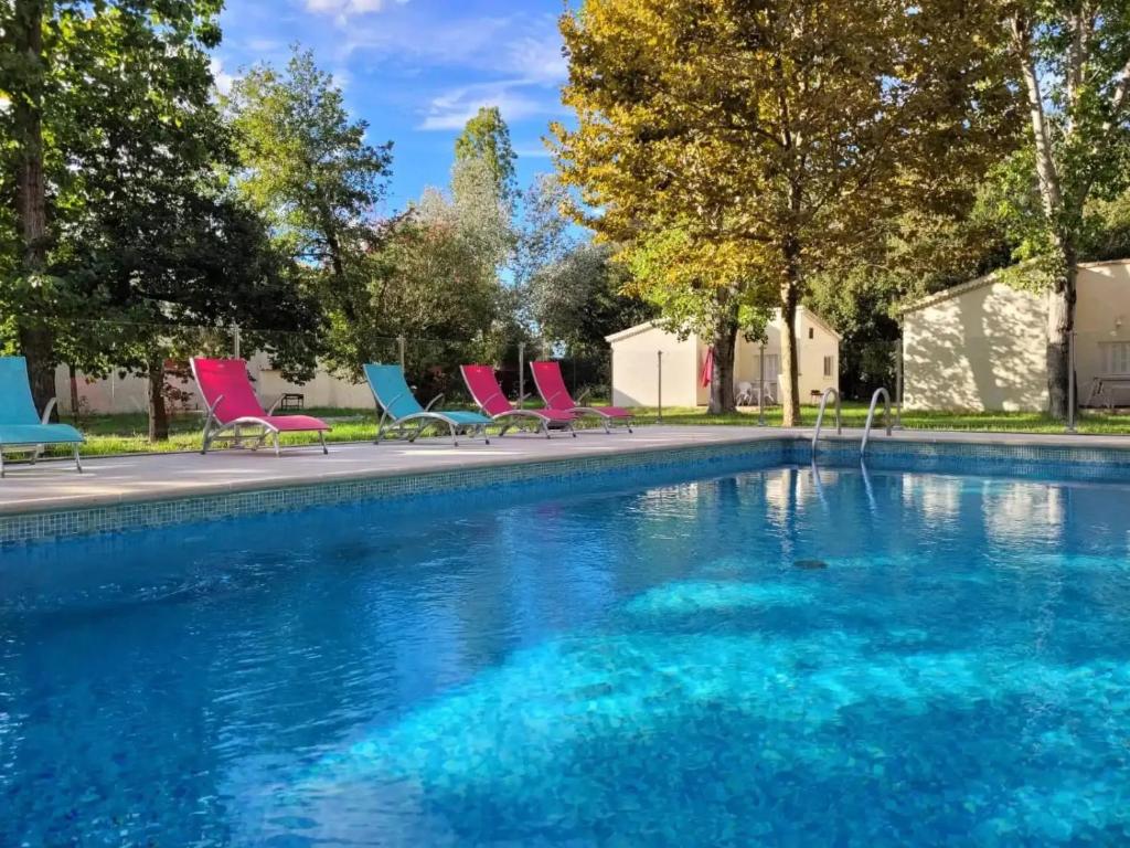 a group of chairs sitting next to a swimming pool at ZEcamping 2 étoiles accès direct à la plage chiens acceptés piscine in Ghisonaccia
