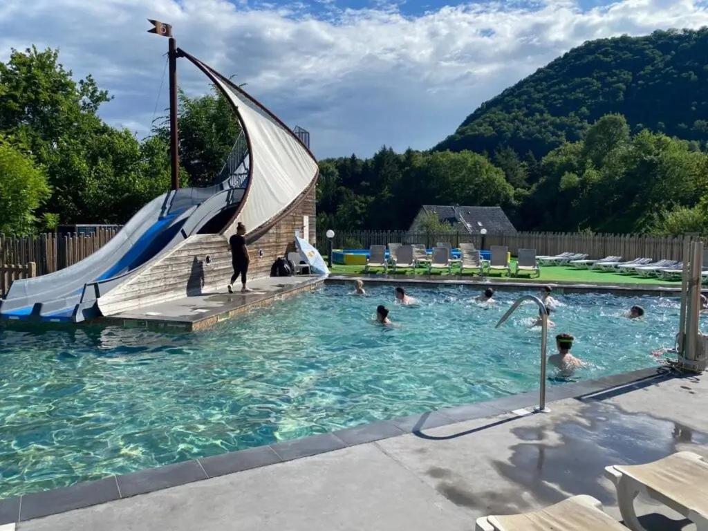 a swimming pool with people in the water at ZEcamping 4 étoiles animaux acceptés tennis piscine couverte in Vic-sur-Cère