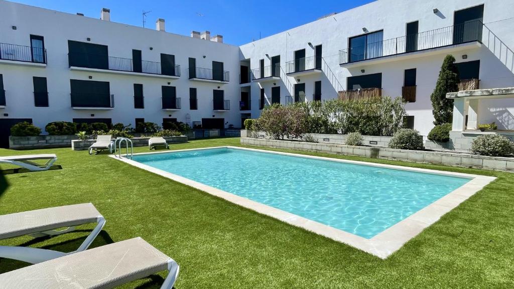a swimming pool in a yard next to a building at Apartament DARSENA B 2-2 in L'Estartit