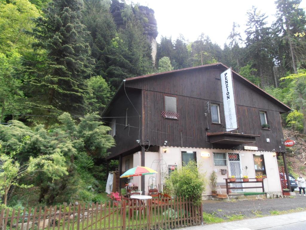 ein Haus mit einem Regenschirm davor in der Unterkunft Penzion Vlasta in Hřensko