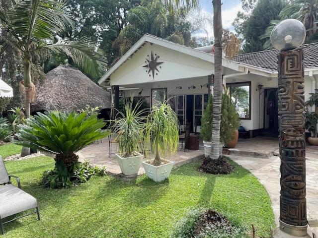 a house with plants in front of it at Sunshine Guest House in Harare