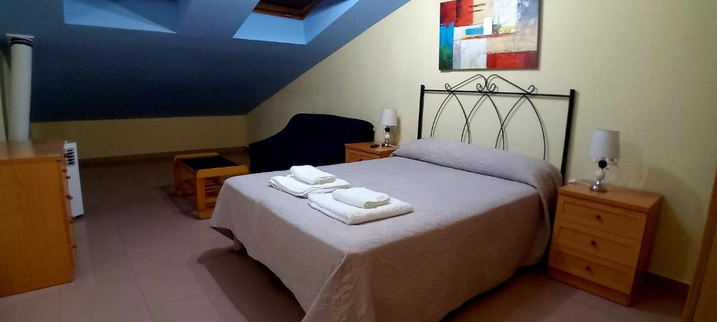 a bedroom with a bed with two towels on it at Apartamento Ático Select Real Caldas de Reis in Caldas de Reis