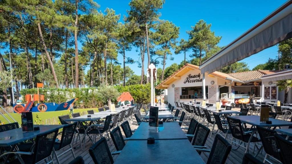 a row of tables and chairs at a restaurant at ZEcamping 5 étoiles avec piscine chauffée dog friendly sauna tennis 3km plage in Vieux-Boucau-les-Bains