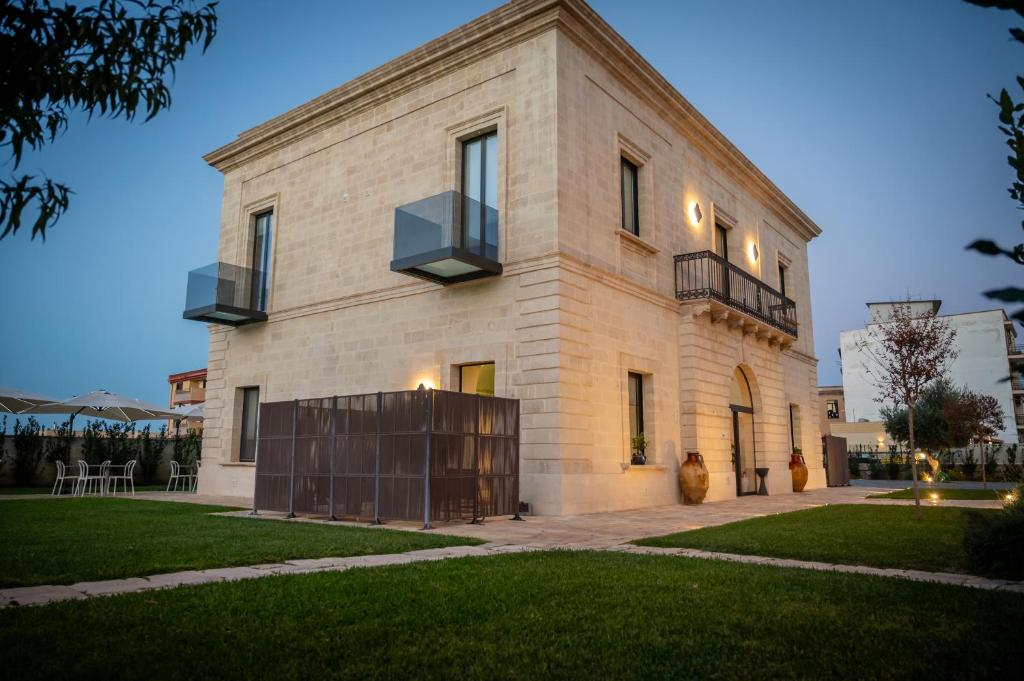a large white brick building with a balcony at Casale della Vittoria - Guest House in Taranto