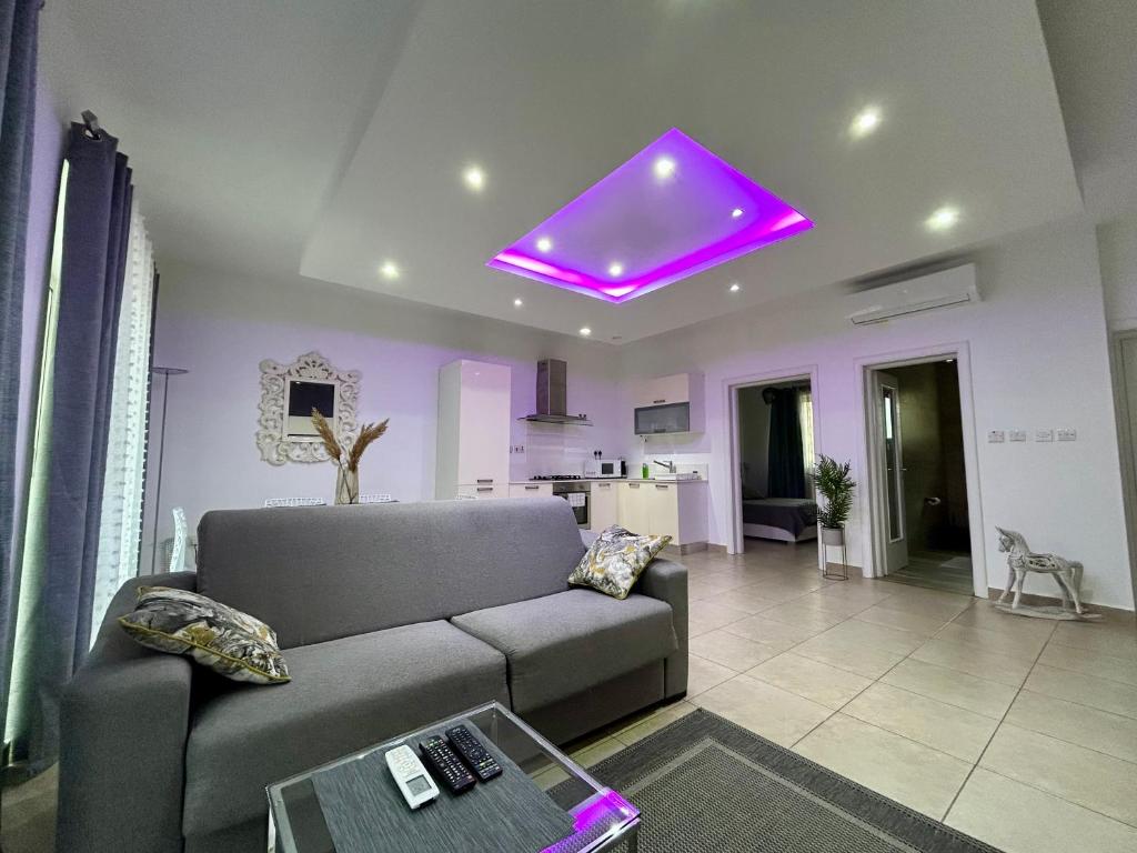a living room with a couch and a purple ceiling at Wedgewood - The XL Suite in Sliema