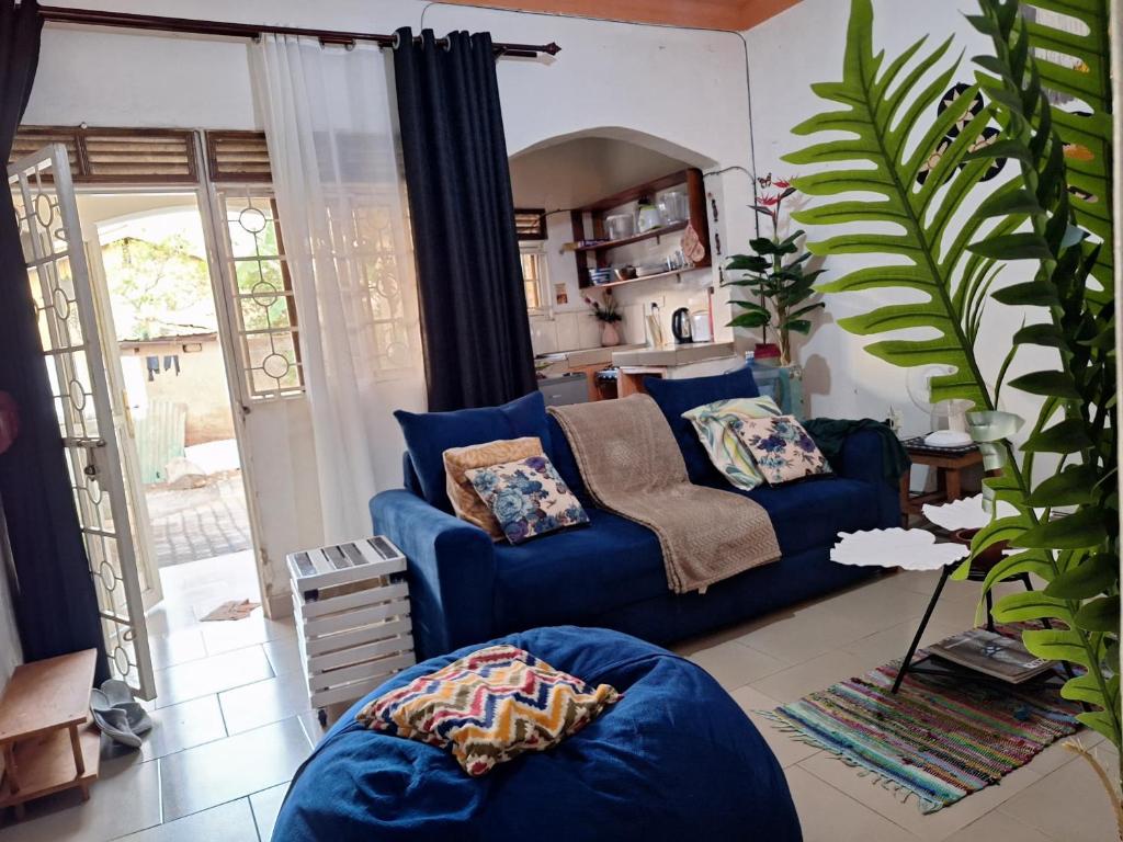 a living room with a blue couch and a table at Homey Stay in Kampala