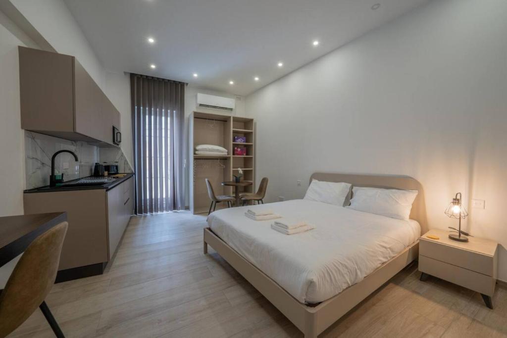 a bedroom with a large bed and a kitchen at Urban Vibe 3 in Kirkop