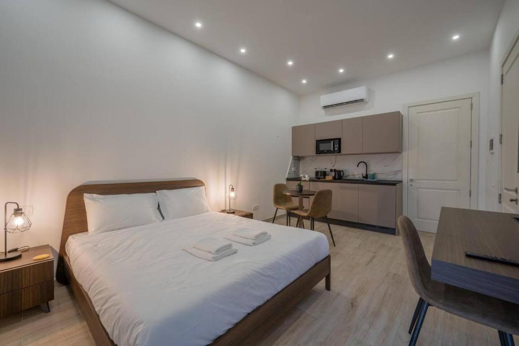 a bedroom with a large bed and a kitchen at Urban Vibe 1 in Kirkop