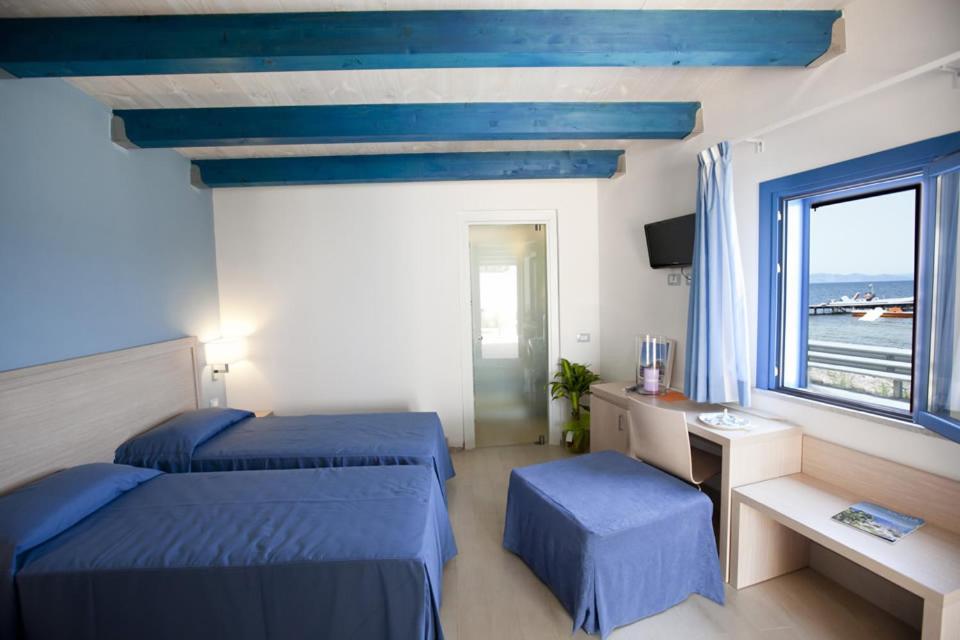 a hotel room with two beds and a window at Sunset Beach in Marausa