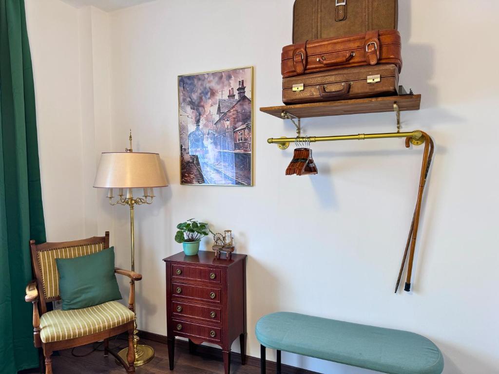 a room with a chair and a table with luggage at Weserblick Hafen-Villa-Bremen in Bremen