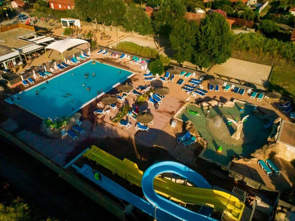 an overhead view of a large swimming pool with chairs and tables at ZEcamping 4 étoiles avec chiens acceptés piscine chauffée à 1km de la plage in Torreilles