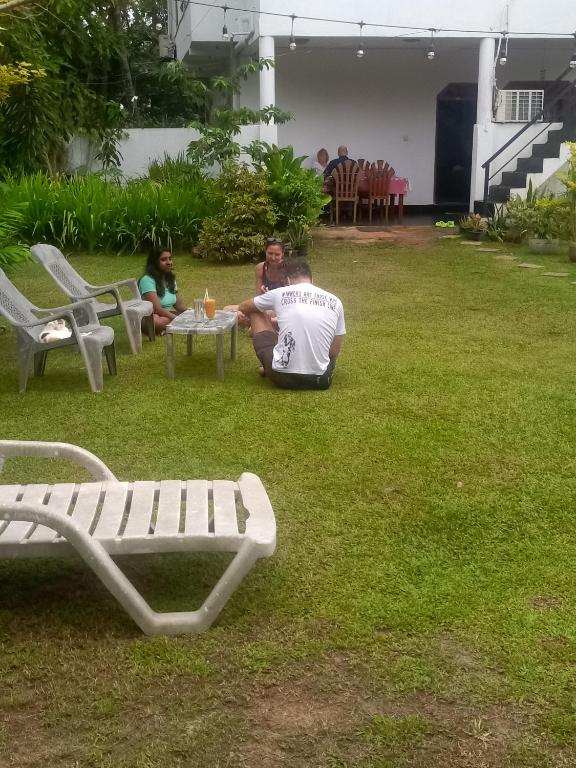 un gruppo di persone sedute attorno a un tavolo sull'erba di Ceylon Sungarden a Habaraduwa Central