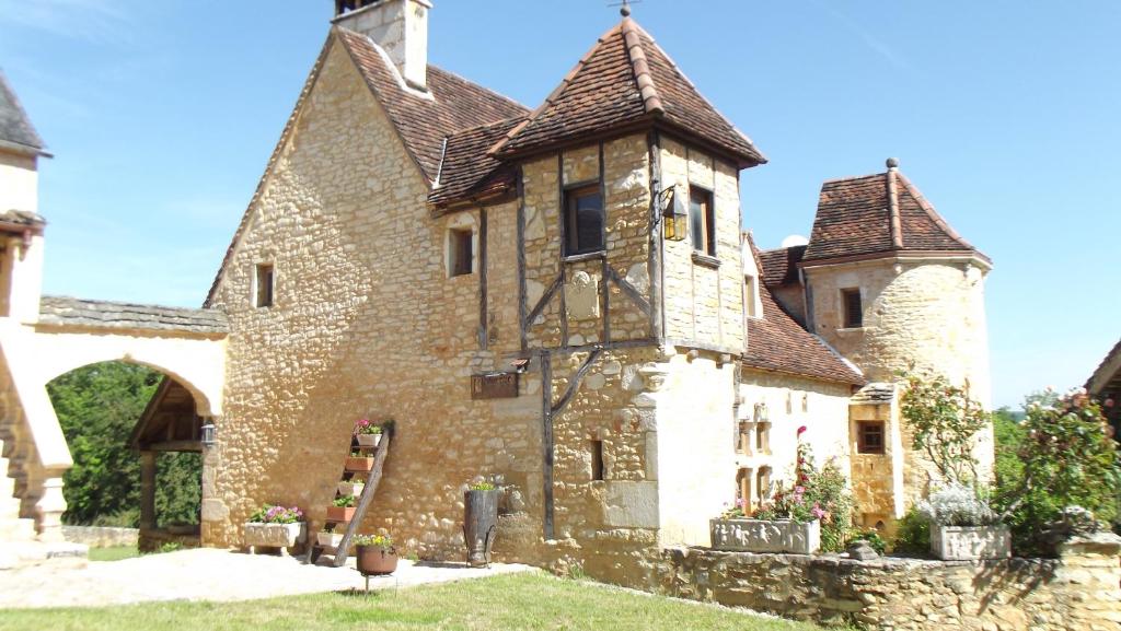 een oud stenen huis met een torentje bij Gites des 3 Vallées in Salignac Eyvigues