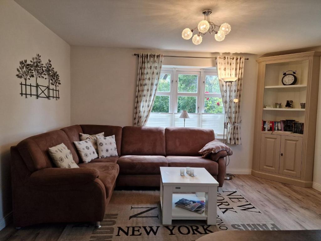 a living room with a brown couch and a table at Goting-Sonne in Borgsum