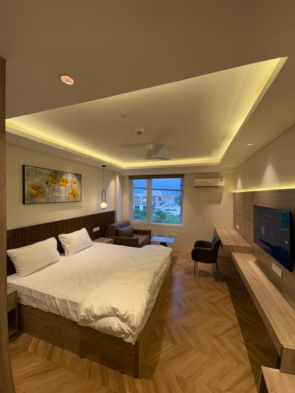 a bedroom with a bed and a flat screen tv at The Sterling Aroma in Greater Noida