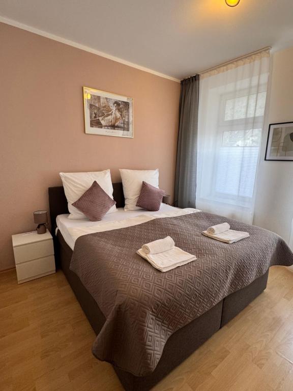 a bedroom with a large bed with two towels on it at Arminos Large Group Apartment- 3 Zimmer & 2 WCs in Chemnitz