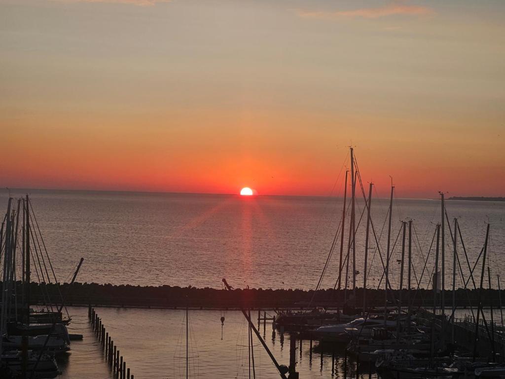a sunset over the water with boats docked at Hafenblick in Kiel