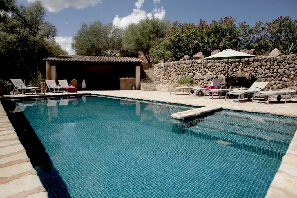 una piscina en un patio con sillas y sombrilla en Agroturismo Can Torna AG178, en Esporles