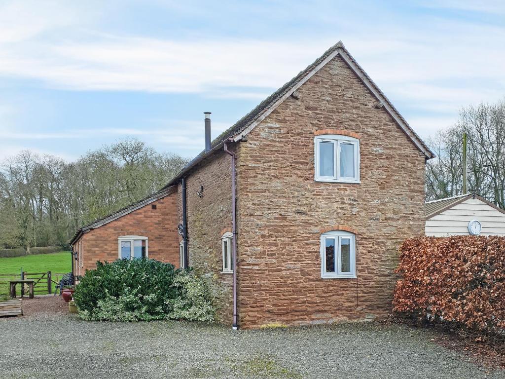 a brick house with white windows in a yard at Howards End in Middleton on the Hill