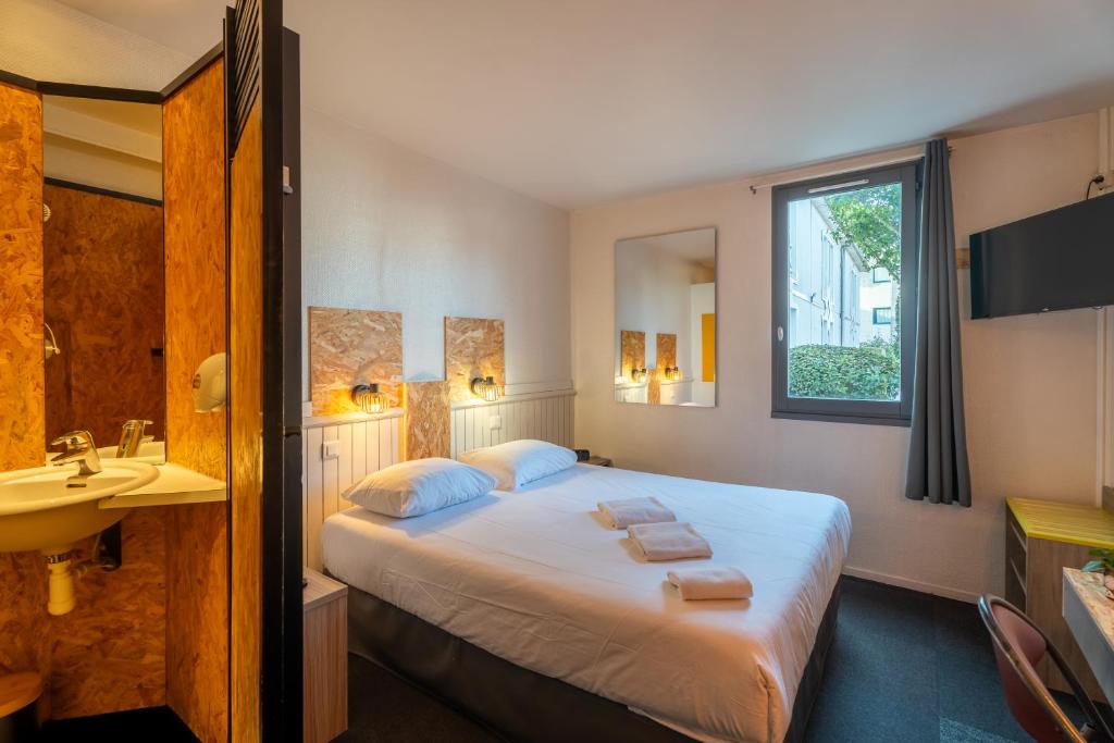 a hotel room with a bed and a sink at Escale Kennedy in Mérignac