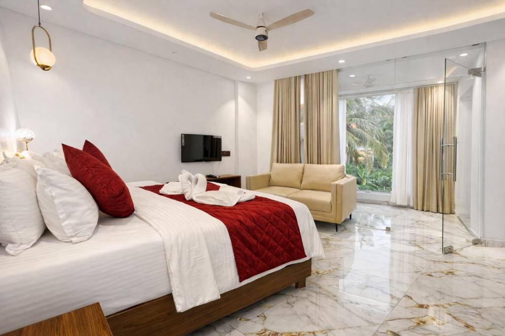 a hotel room with a bed and a chair at Hotel Materhorn in Kovalam