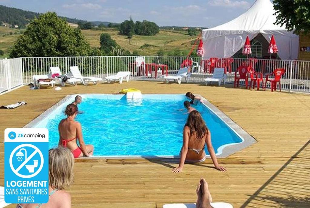 a group of people sitting around a swimming pool at ZEcamping 3 étoiles dog friendly piscine chauffée en bordure de l'Allier in Lespéron