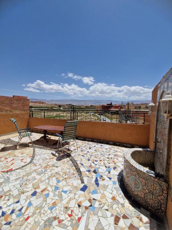 a patio with a table and chairs on a mosaic floor at Panoramic House - Midelt Family Triplexe in Midelt
