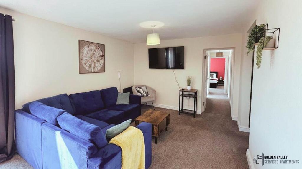 a living room with a blue couch and a table at Modern & Spacious Flat with Balcony Views in Gloucestershire