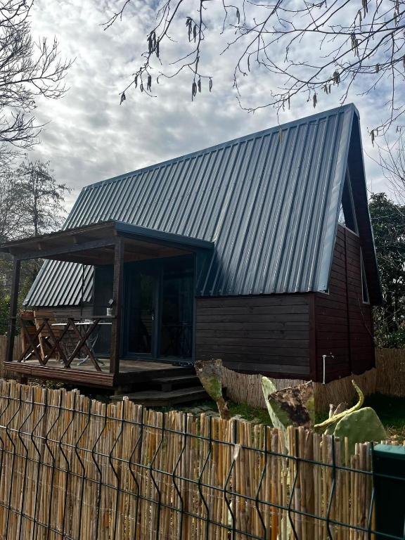 a house with a metal roof on top of a fence at Akorya bungalov in Ardeşen