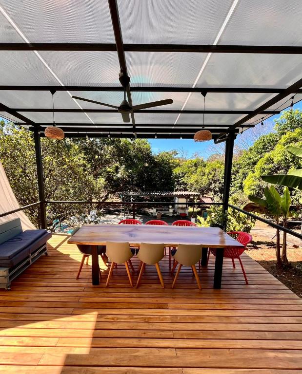a patio with a table and chairs on a deck at Casa Rural Los Almendros - Tarcoles in Capulín