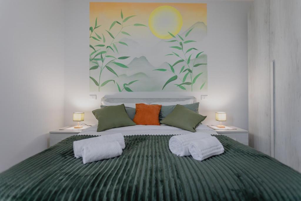 a bedroom with a large bed with green and orange pillows at Casa Dama in Casaleone