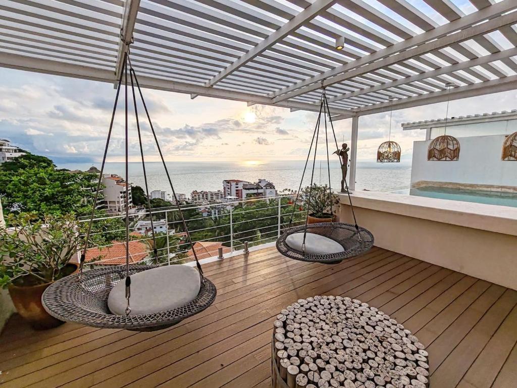 a balcony with chairs and a view of the ocean at Unique Designer Gem with Private Pool, Elevator, Views in Puerto Vallarta