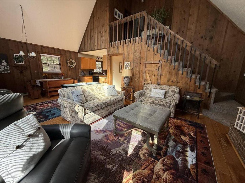 a living room with a couch and a staircase at Alpine Getaway 62 in Helen