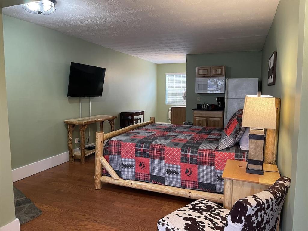 a bedroom with a bed and a tv and a couch at Bavarian Brook Unit 7 in Helen