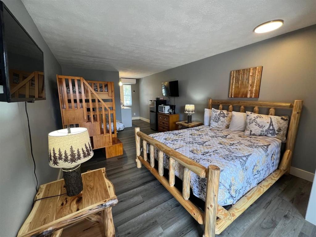 a bedroom with a wooden bed and a television at Bavarian Brook Unit 4a in Helen
