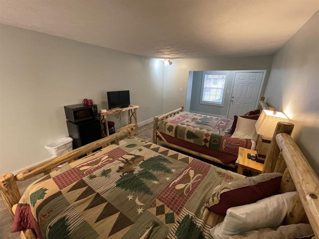 a bedroom with two beds and a couch and a tv at Bavarian Brook Unit 6A in Helen