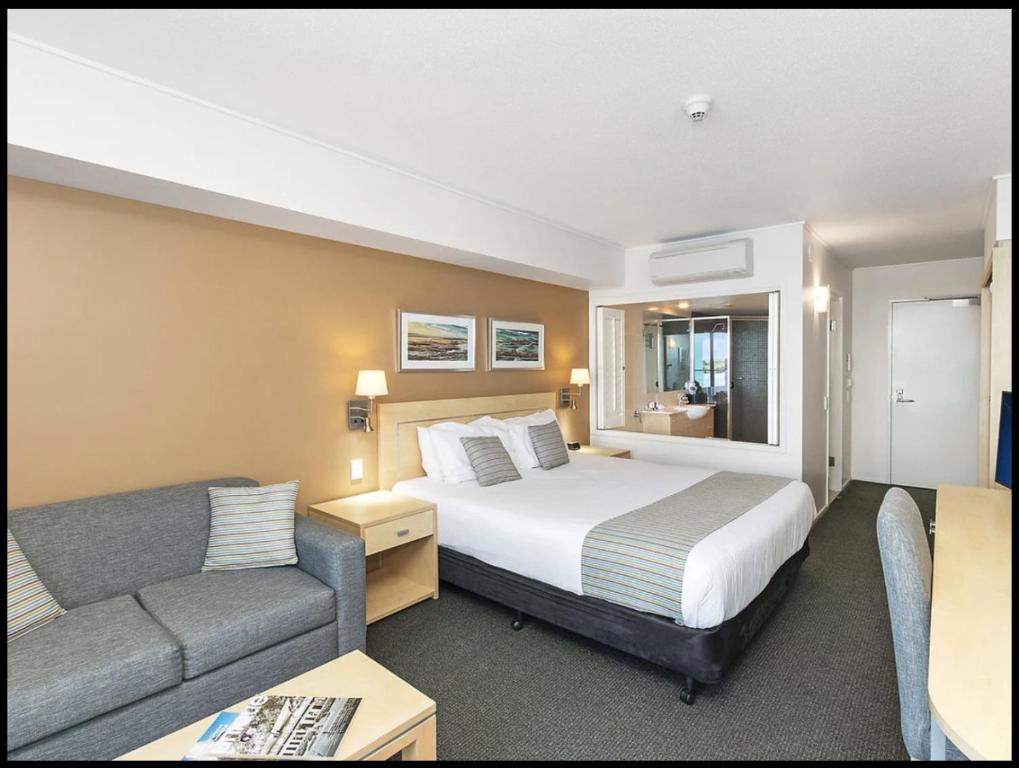 a hotel room with a bed and a couch at Water Front Retreat Ballina in Ballina