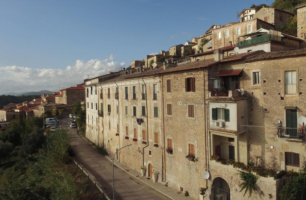 een groep gebouwen aan de zijkant van een heuvel bij Palazzo Tronconi in Arce