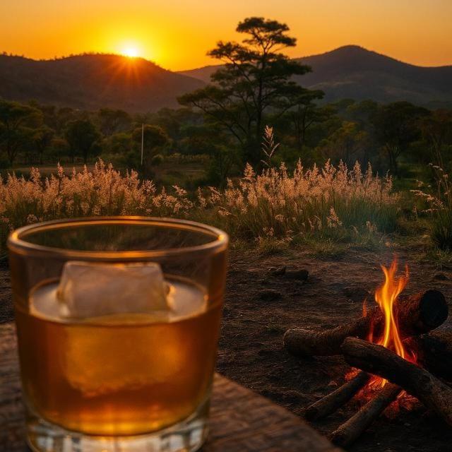 a glass of beer sitting next to a camp fire at Chalé Corina in Pirenópolis