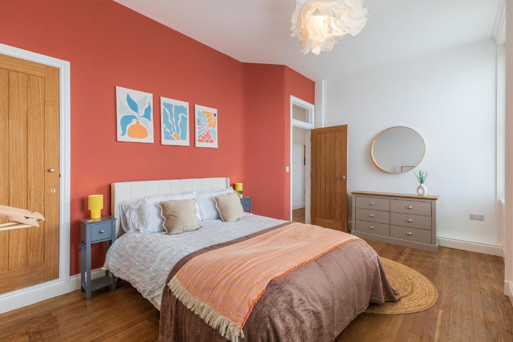 a bedroom with a bed with a red wall at Harbour-View Apartment Facing HMS Warrior in Portsmouth