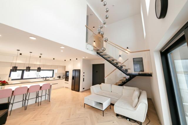 a living room with a white couch and a staircase at Pajupera Villa in Pärnu