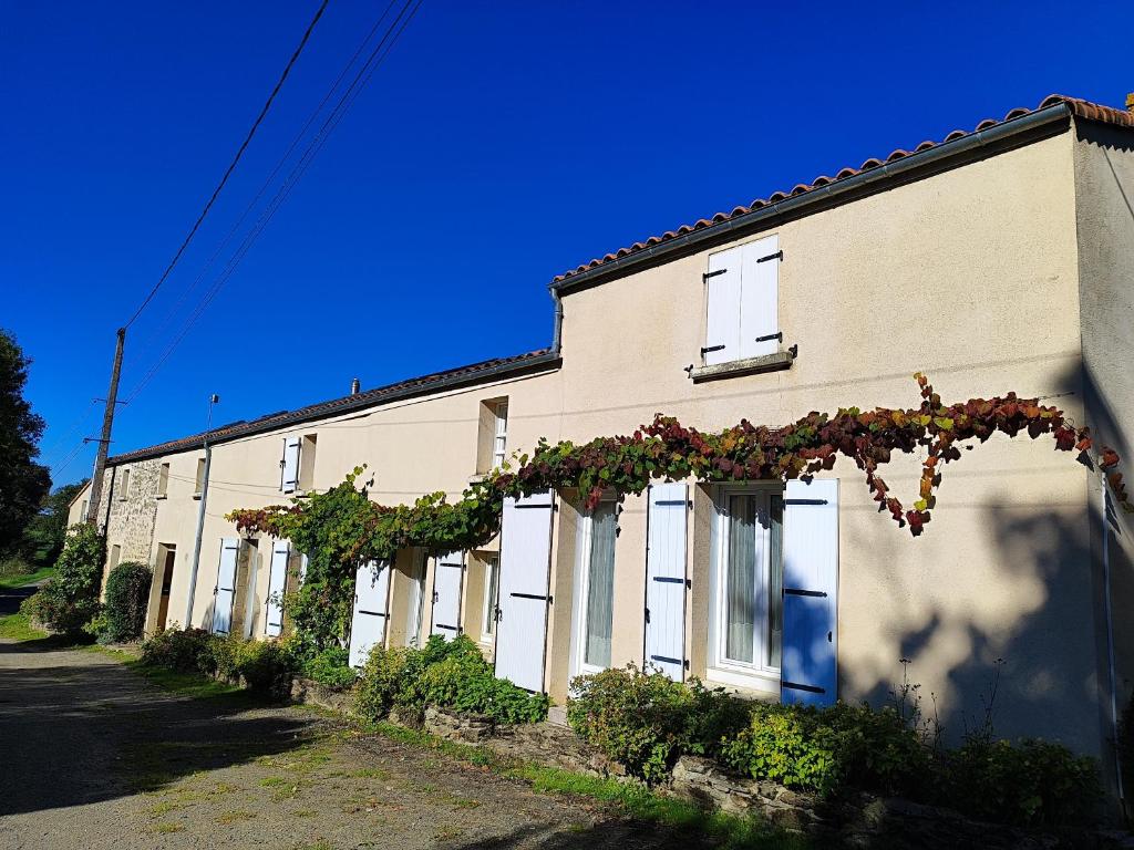 a building with flowers on the side of it at L'Orée du Puy in Les Herbiers