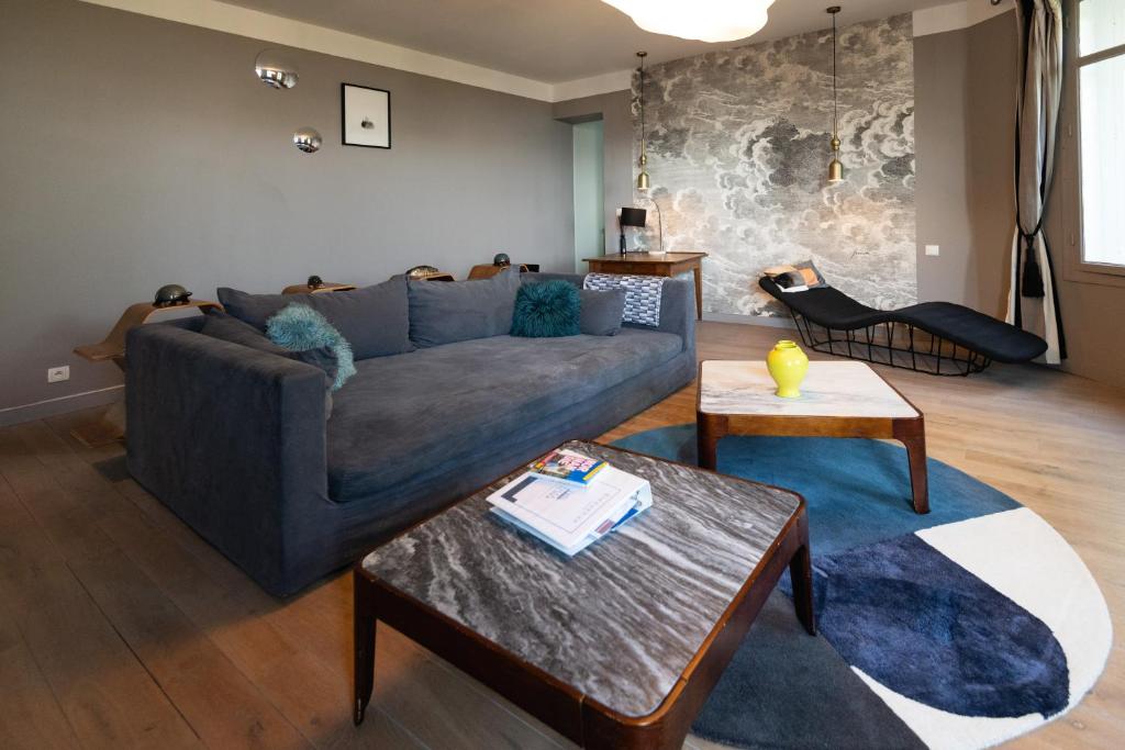 a living room with a couch and a table at Maison Valmer - L'armateur, élégant penthouse classé 4 étoiles in Le Havre